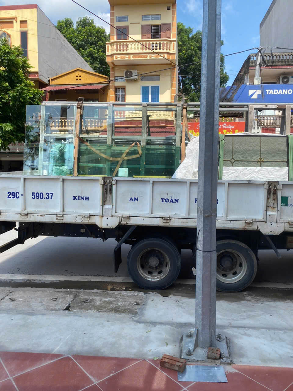 Xe tải chở kính cường lực an toàn được cố định trên giá đỡ chuyên dụng ngoài trời